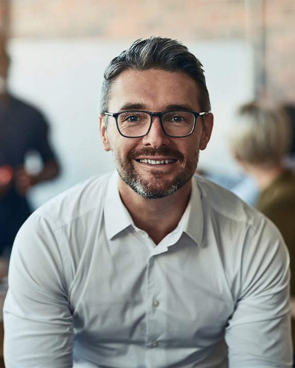 A smiling man wearing glasses