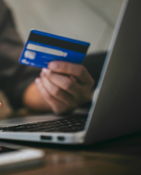 Person entering payment card information on laptop