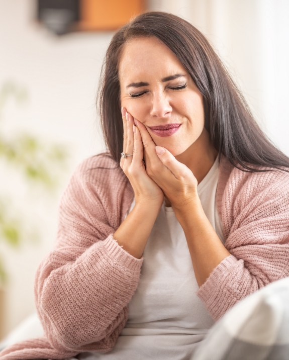 Wincing woman holding her jaw