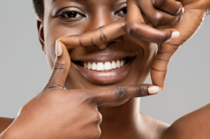 Close up of woman outlining her smile with her fingers